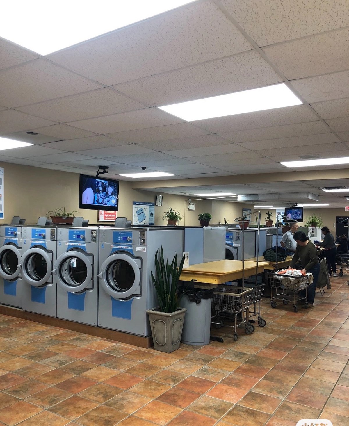Bright interior of Magic Coin Laundry with rows of washers